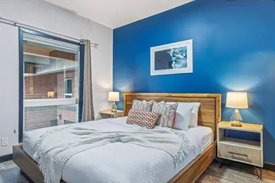 a bedroom with blue walls and a bed with pillows at Perfect Rockies Escape with Pool, Hot Tub and Gym in Canmore