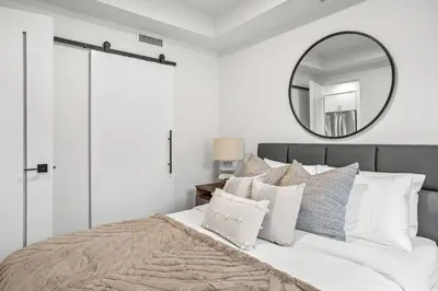 a bedroom with a large bed with a mirror at Brand New 1BR Canmore Retreat Hot Tub, Sauna, Gym in Canmore