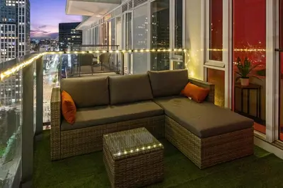 a couch on a balcony with a view of a city at Downtown Calgary Modern 1BR with Pullout couch in Calgary