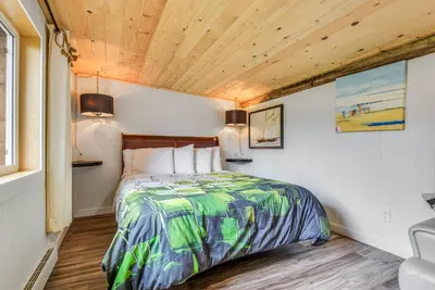 a bedroom with a bed and a wooden ceiling at The Wood Shed with hot tub in Oyster Bay