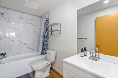 a bathroom with a white toilet and a tub and a sink at Acreage, 3 King Beds and Ensuites, Dance Floor, Fireplace, AC in Calgary