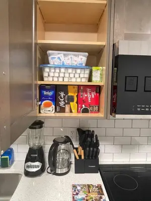 a kitchen counter with a cupboard filled with food at Cozy and modern two bedroom guest suite in Calgary