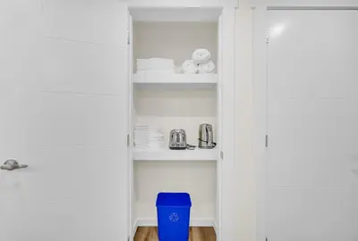 a pantry with white shelves and a blue trash can at Brand New Private Secondary Suite in Mahogany in Calgary
