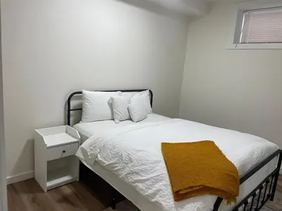 a bedroom with a bed with a yellow blanket on it at Brand New Private Secondary Suite in Mahogany in Calgary