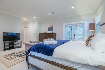 a bedroom with a large bed and a television at Prime Richmond Stay 10 min to YVR & Steveston in Richmond