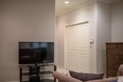 a living room with a television and a couch at Prime Richmond Stay 10 min to YVR & Steveston in Richmond