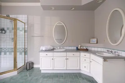 a bathroom with two sinks and two mirrors at Prime Richmond Stay 10 min to YVR & Steveston in Richmond