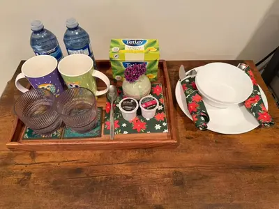 a table with a tray with cups and plates and water at Prime Richmond Stay 10 min to YVR & Steveston in Richmond