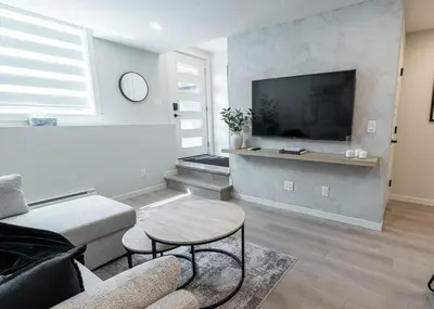 a living room with a couch and a tv at YYC Retreat - Near Mountains & Airport in Calgary
