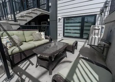 a patio with a couch and a table on a balcony at YYC Retreat - Near Mountains & Airport in Calgary