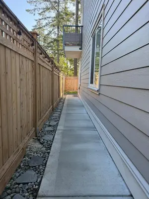 a walkway next to a house with a fence at Modern 1BR Suite with Laundry, Workspace & WiFi in Langford