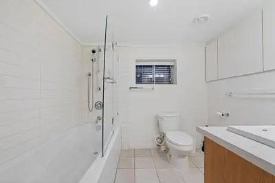 a white bathroom with a shower and a toilet at Renovated North Vancouver Gem in North Vancouver