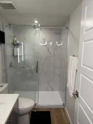 a bathroom with a glass shower with a toilet at Serenity Suite 3603 in Edmonton