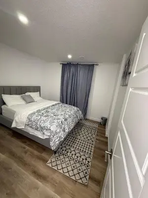 a bedroom with a bed and a blue curtain at Serenity Suite 3603 in Edmonton