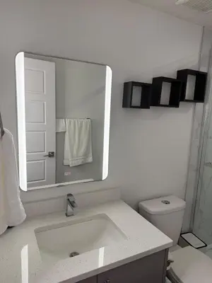 a white bathroom with a sink and a toilet at Serenity Suite 3603 in Edmonton