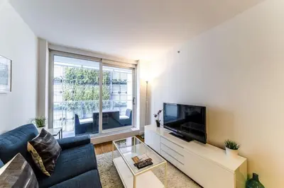 a living room with a blue couch and a large window at Corporate Stays Telus Gardens 1 Bedroom in Vancouver