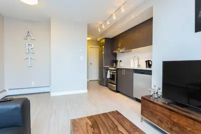 a living room with a television and a kitchen at Corporate Stays Hendrix - 2 Bedrooms in Edmonton