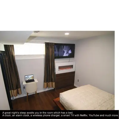 a bedroom with a bed and a tv on the wall at beautiful private house in Edmonton