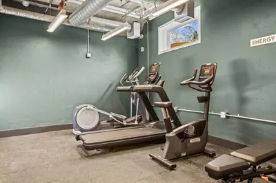 a gym with three exercise bikes in a room at 4BR Golden Ridge Mountain Escape with Hot Tub and Gym in Canmore