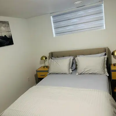 a bed with two pillows and a window in a bedroom at Modern Basement Suite near West Edmonton Mall in Edmonton