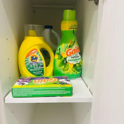 two bottles of cleaning products and a box in a closet at Modern Basement Suite near West Edmonton Mall in Edmonton