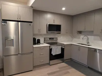 a kitchen with stainless steel appliances and wooden cabinets at 21 Greenwich Common NW Calgary Alberta in Calgary