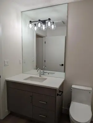 a bathroom with a sink and a mirror at 21 Greenwich Common NW Calgary Alberta in Calgary