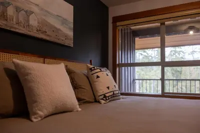 a bedroom with a bed with pillows and a window at Fully Renovated Penthouse Loft at Fernie Alpine Resort in Fernie