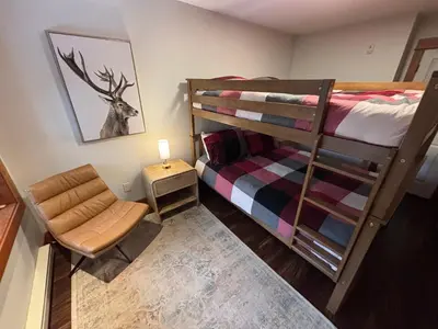a small room with a bunk bed and a chair at Fully Renovated Penthouse Loft at Fernie Alpine Resort in Fernie