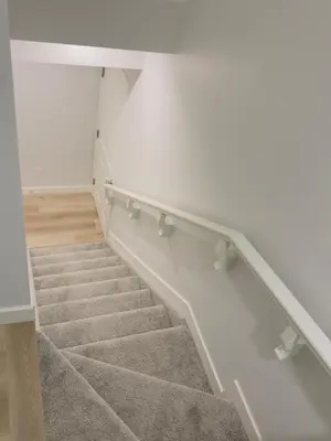 a staircase in a room with white walls and carpet at Modern Comfort West Edmonton in Edmonton