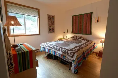 a bedroom with a bed and a lamp and a window at Pemberton Tree Lodge in Pemberton