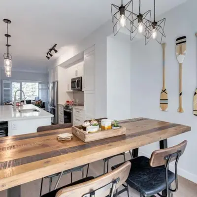 a kitchen with a large wooden table and chairs at Stunning Modern 2BR Unit in Downtown Canmore in Canmore