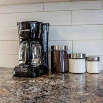 a blender sitting on top of a counter next to three containers at BoHo House-Sleeps 17-Garage-3 Kitchens-Fireplace in Edmonton