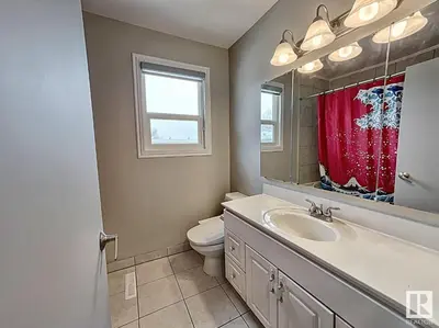 a bathroom with a toilet and a sink and a mirror at UofA Bike Lane-Train-Bus- Southgate Mall, Cental in Edmonton