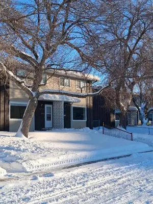 a house is covered in snow with a tree at UofA Bike Lane-Train-Bus- Southgate Mall, Cental in Edmonton