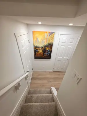 a hallway with stairs and a painting on the wall at Amaville - One BRM Private Suite in West Edmonton in Edmonton