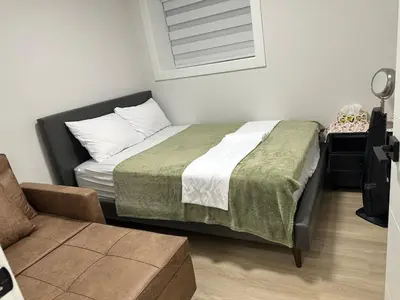 a small bedroom with a bed and a chair at Metrotown area in Vancouver