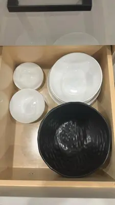 three white plates and a black bowl on a shelf at Metrotown area in Vancouver