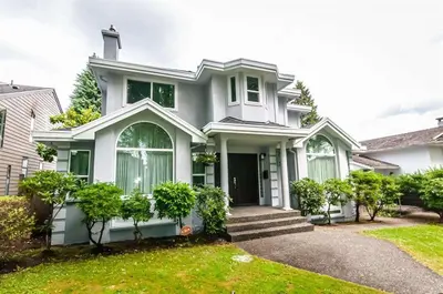 a white house with a green yard at W 20 House in Vancouver