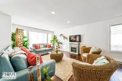 a living room with a blue couch and chairs at Spacious 6BDR Oasis - Sleeps 17 - Garage - Fireplace in Edmonton