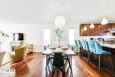 a kitchen and dining room with a table and blue chairs at Spacious 6BDR Oasis - Sleeps 17 - Garage - Fireplace in Edmonton