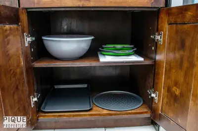 a wooden cabinet with a bowl and plates in it at Spacious 6BDR Oasis - Sleeps 17 - Garage - Fireplace in Edmonton