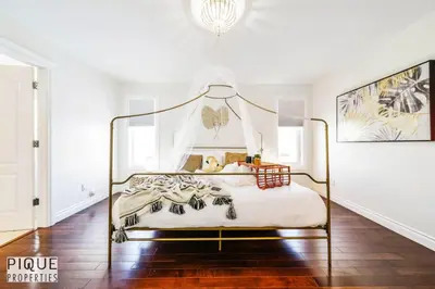 a bedroom with a canopy bed in a white room at Spacious 6BDR Oasis - Sleeps 17 - Garage - Fireplace in Edmonton