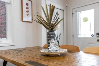 a dining room table with a vase on top of it at Luxe Escape Duo - 8 Beds - Sleeps 22 - 4 Car Garage in Edmonton