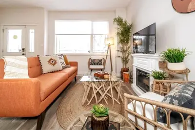 an orange couch in a living room with a fireplace at Luxe Escape Duo - 8 Beds - Sleeps 22 - 4 Car Garage in Edmonton