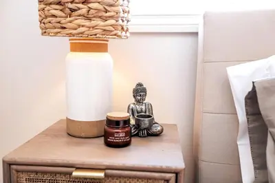 a nightstand with a lamp and a bottle of honey at Luxe Escape Duo - 8 Beds - Sleeps 22 - 4 Car Garage in Edmonton