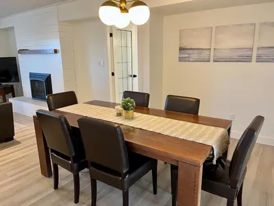 a dining room with a wooden table and chairs at Camelia Home in Kelowna