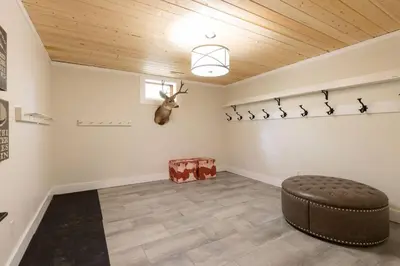 a room with a ottoman and a antelope on the wall at True North Chalet by Fernie Central Reservations in Fernie