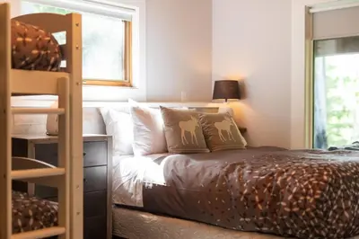 a bedroom with a bed and a bunk bed at True North Chalet by Fernie Central Reservations in Fernie