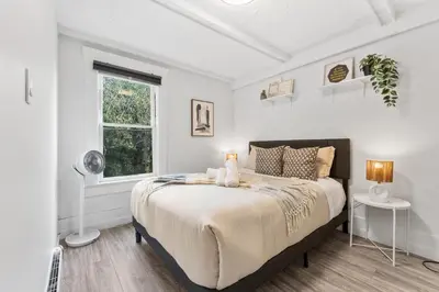 a bedroom with a bed and a window at Heritage Home in Heart of City with free Parking in Vancouver